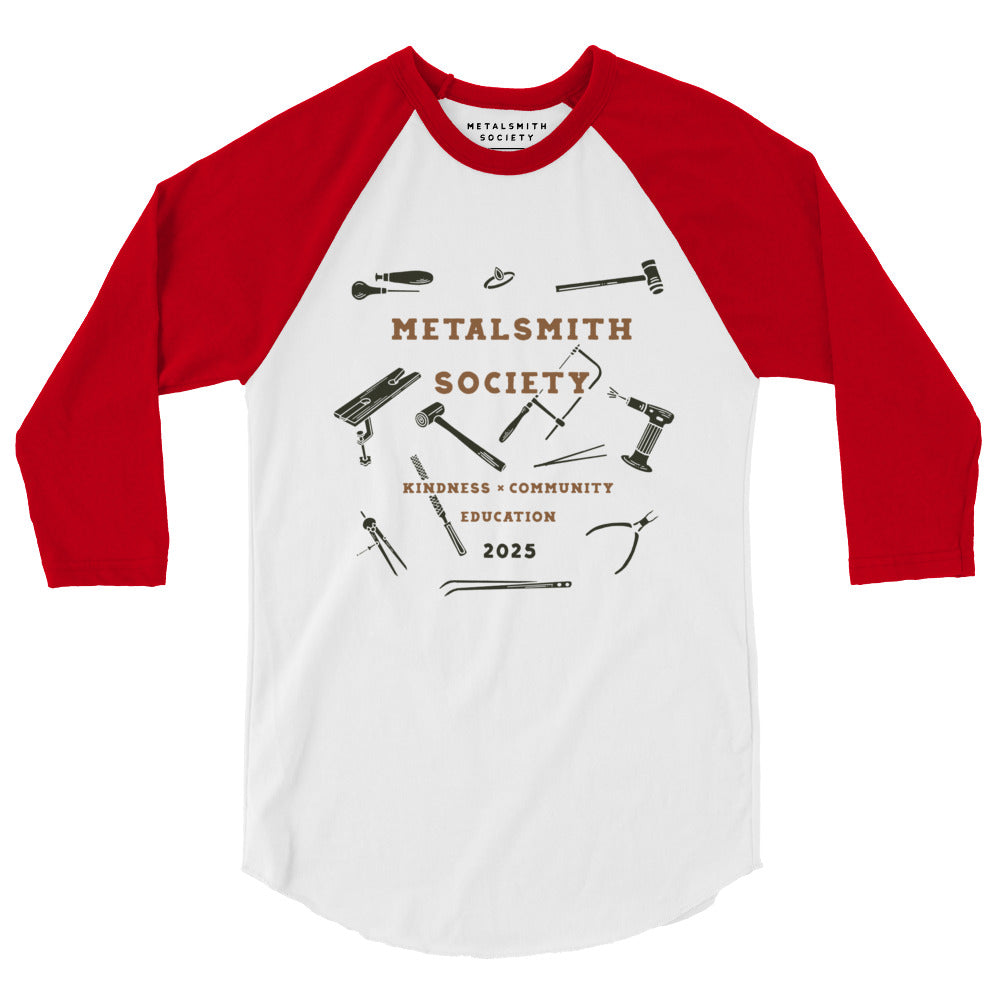 Front View of Shirt: A front-facing image of the 2025 Society Raglan Shirt featuring a white body with contrasting red raglan sleeves. The Limited Edition 2025 Metalsmith Society's logo is prominently displayed on the chest with illustrations of jewerlry tools.