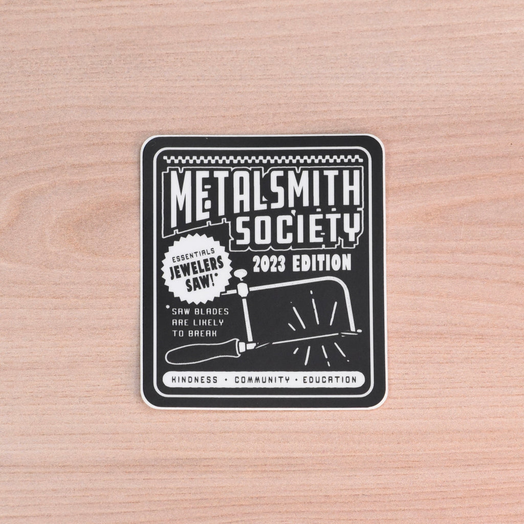 Metalsmith Society 2023 Edition sticker featuring jeweler’s saw and typography design