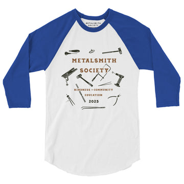 Front View of Shirt: A front-facing image of the 2025 Society Raglan Shirt featuring a white body with contrasting royal blue raglan sleeves. The Limited Edition 2025 Metalsmith Society's logo is prominently displayed on the chest with illustrations of jewerlry tools.