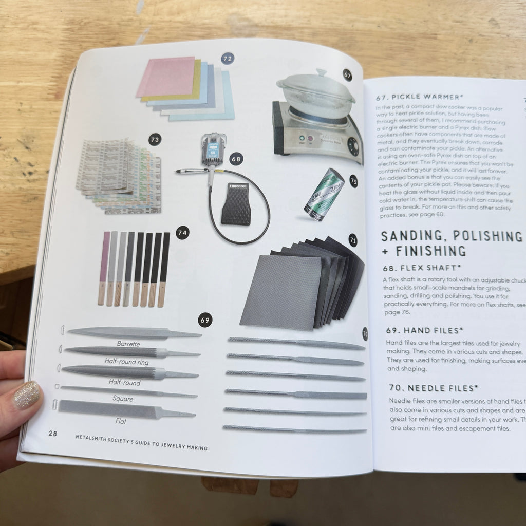 Open book showing jewelry-making tools and techniques on a wooden surface