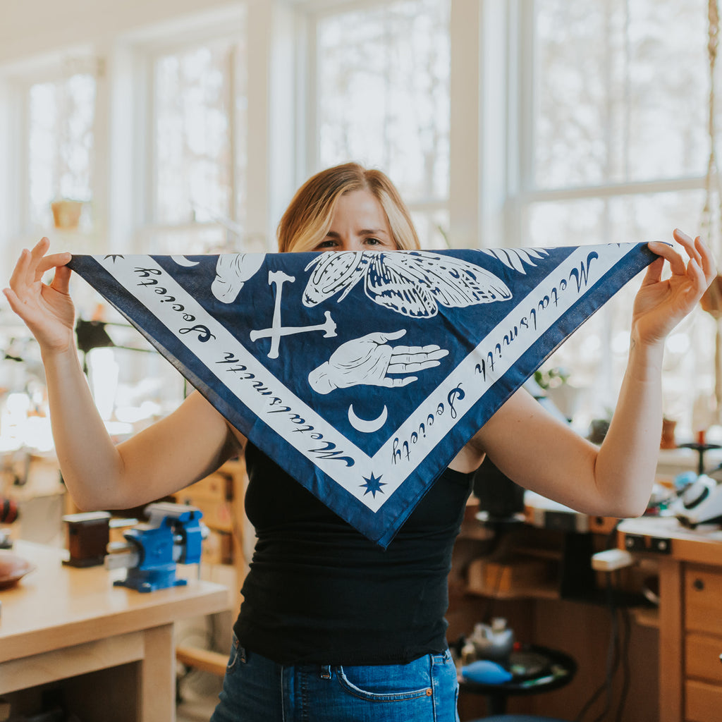 2022 Bandana folded to feature navy fabric with crisp white ink illustrations, styled neatly for display.